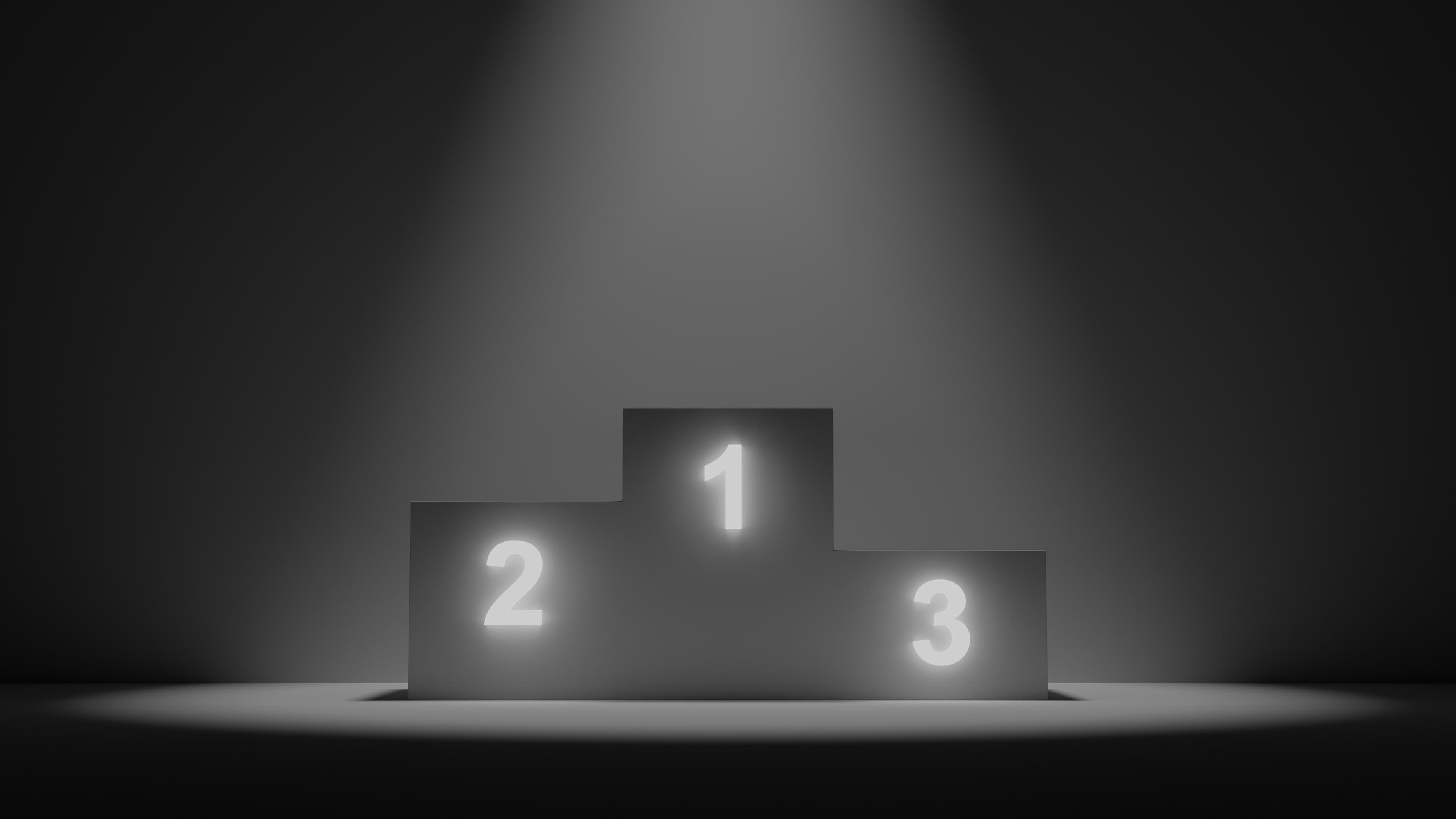 Podium with places 1, 2 and 3 lit by a spotlight in a dark room