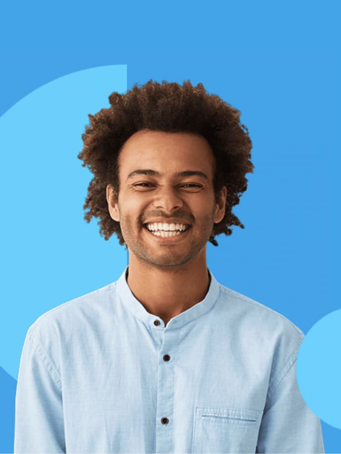 Smiling man with curly hair in a light blue shirt against a bright blue background with pale blue circles