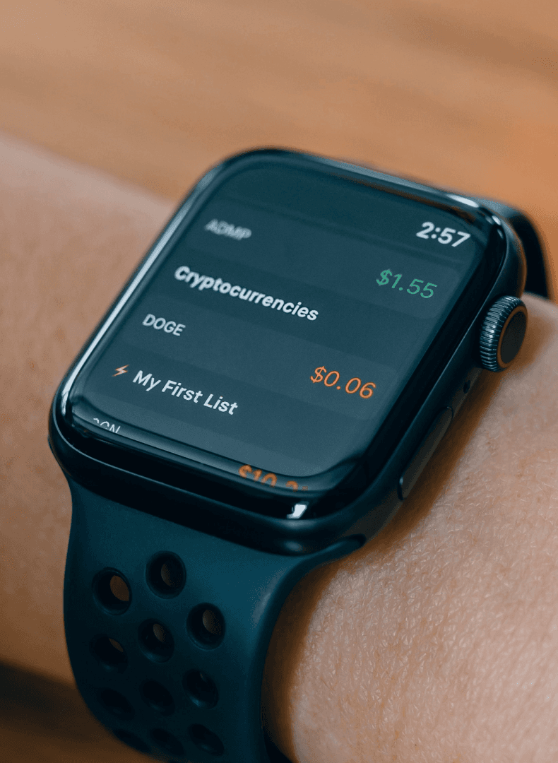 Smartwatch on a wrist showing a cryptocurrency list with prices in green and orange