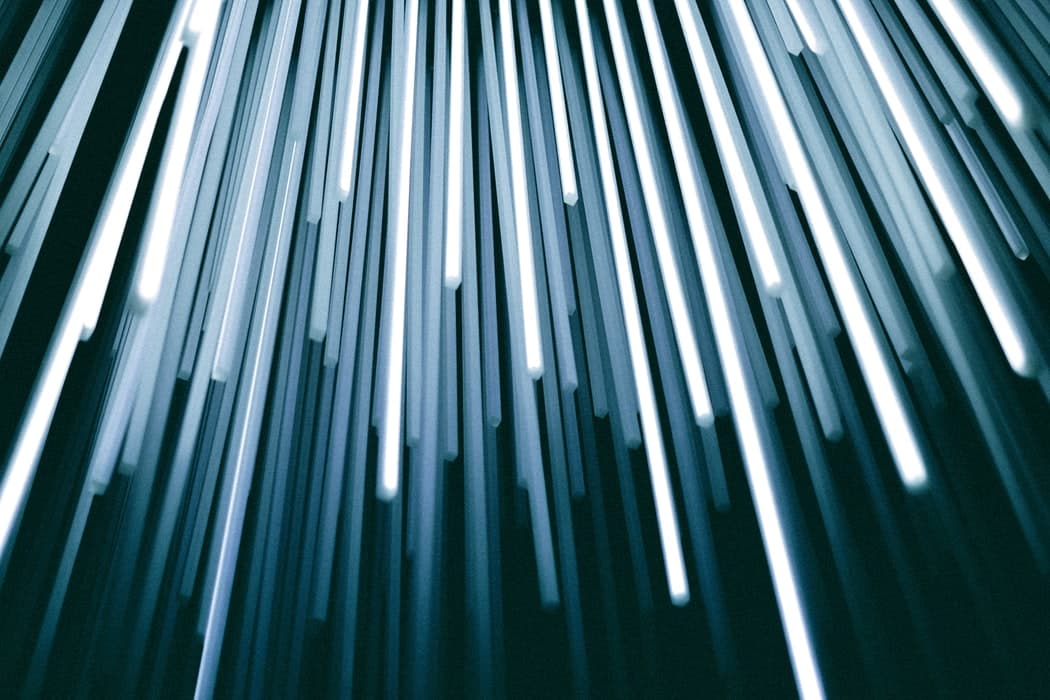 Blurred white and blue streaks of light falling against a dark background