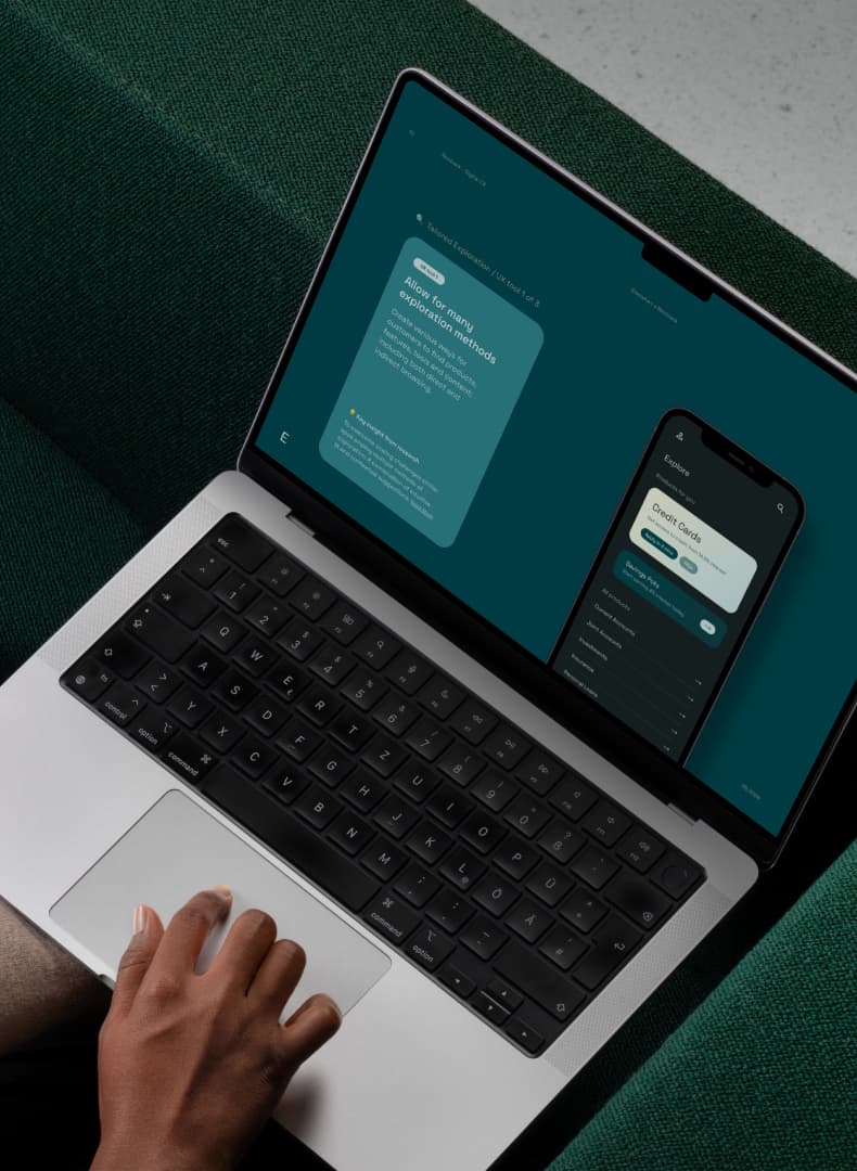 Person using a laptop displaying an app design interface, with a smartphone layout shown on the screen.